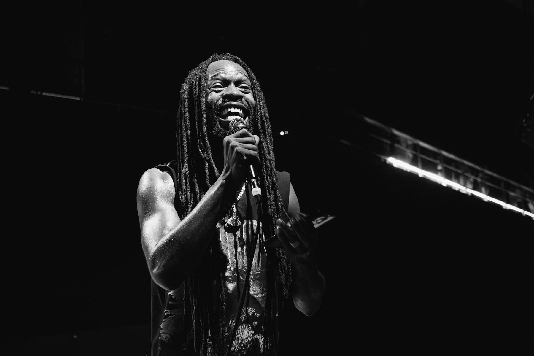 Black and white photo of a singer with long locs performing