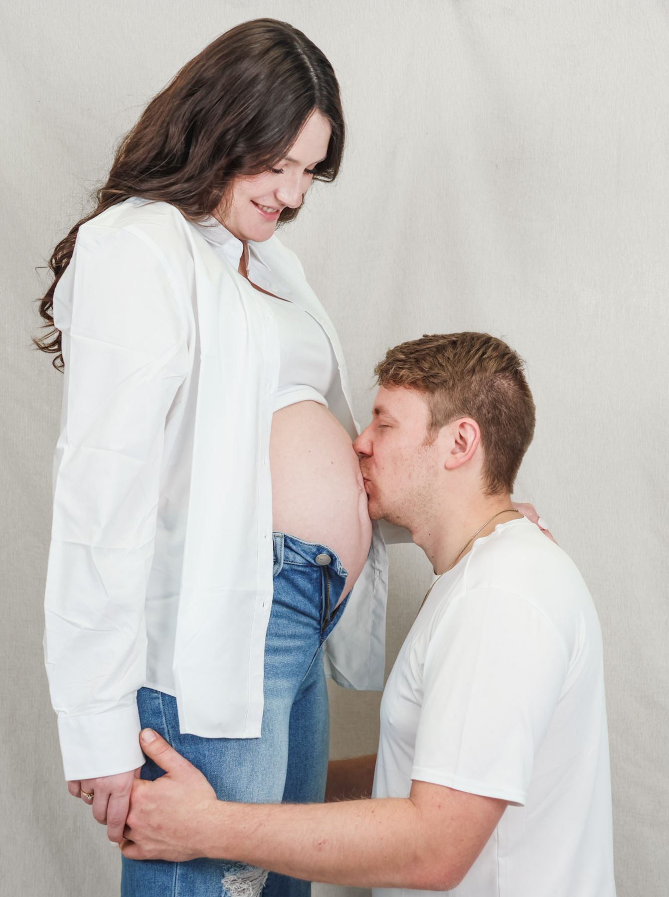 Man kissing his pregnant partner's belly